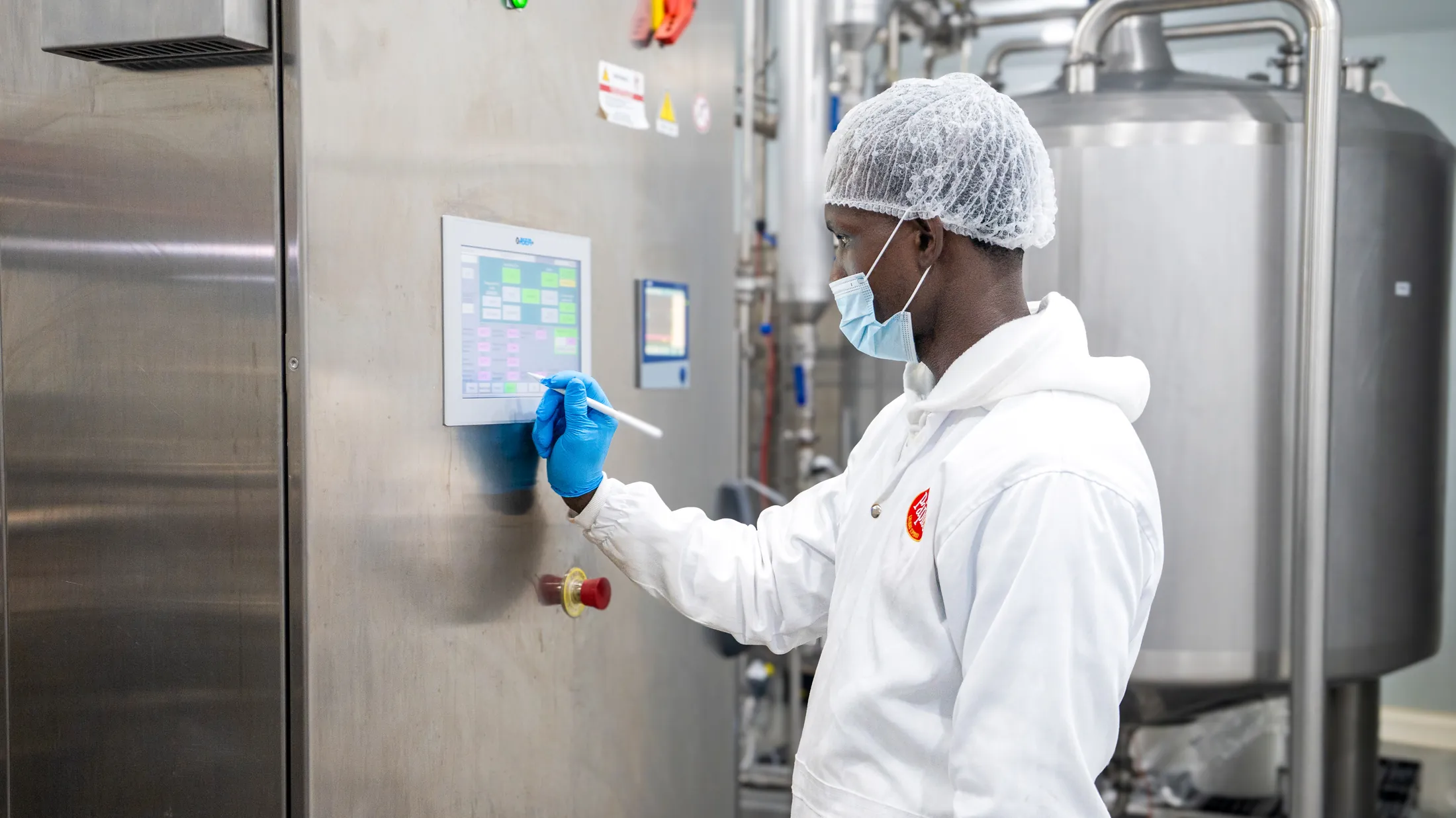 Operador supervisando el ciclo de pasteurización desde el panel de control